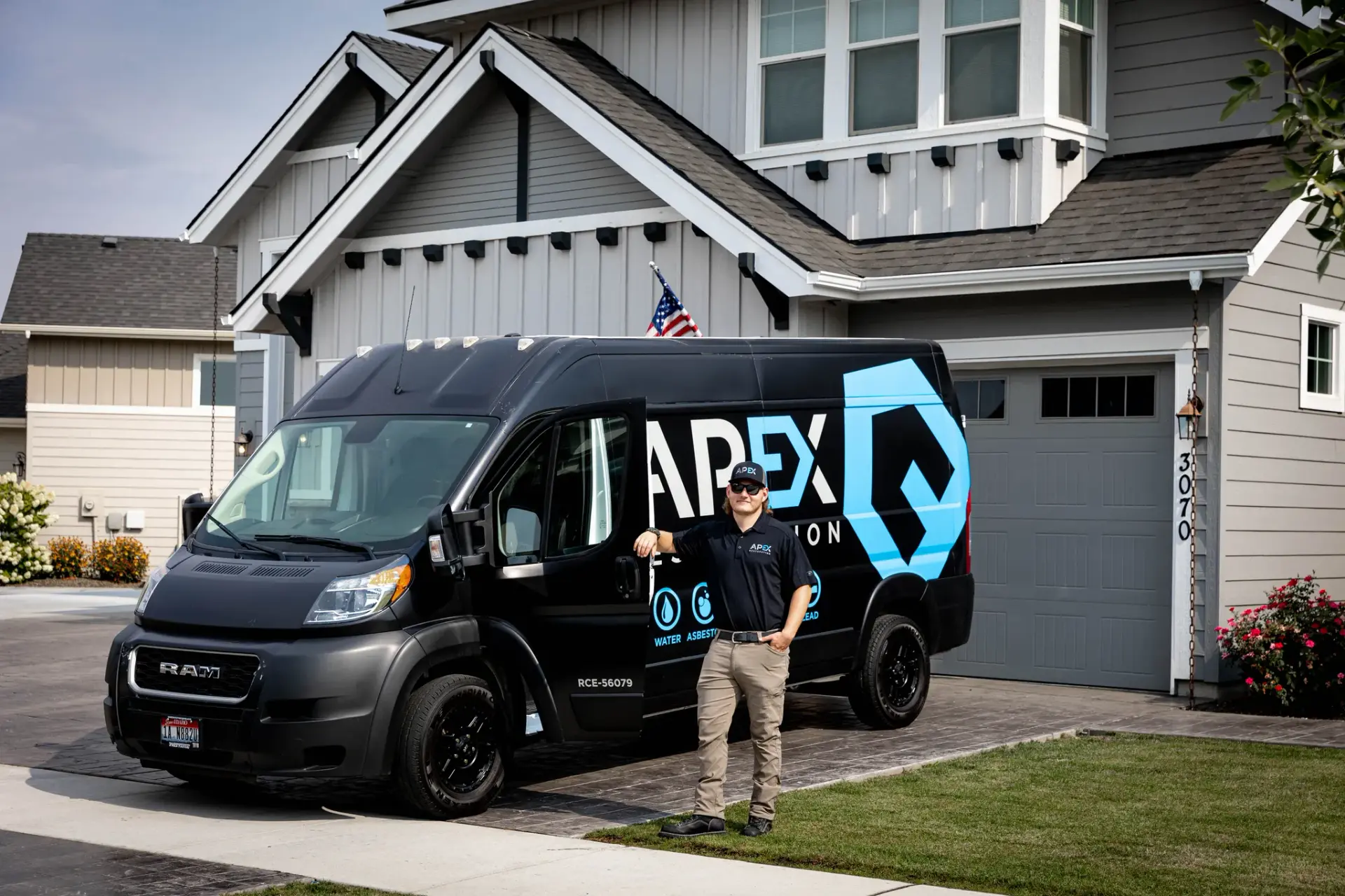 Technician standing beside a branded service van, water damage restoration in Idaho and Eastern Washington