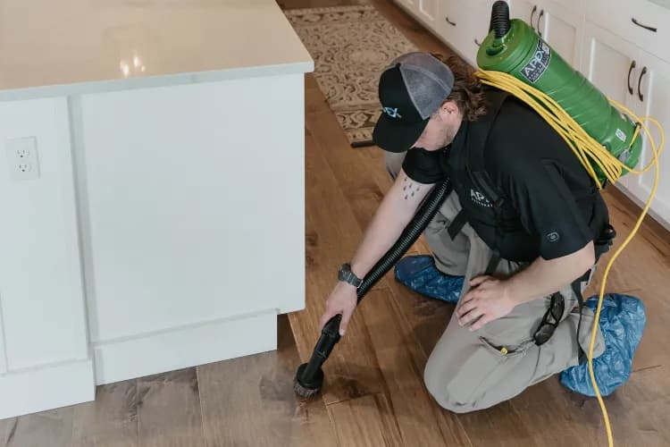 Apex Restoration technician extracting water from a hardwood floor during our water damage repair process in Boise, ID